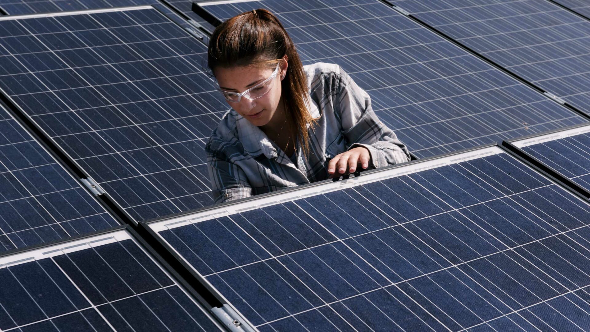 Woman inspects a solar panel