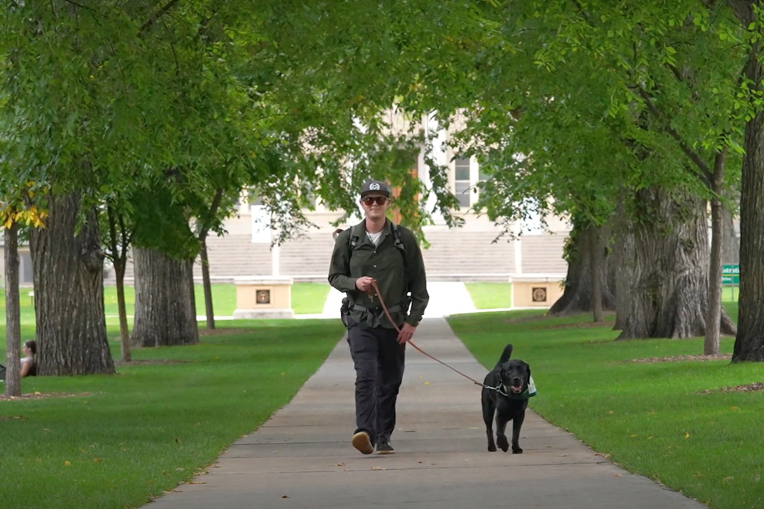 Student walking down Oval with service dog