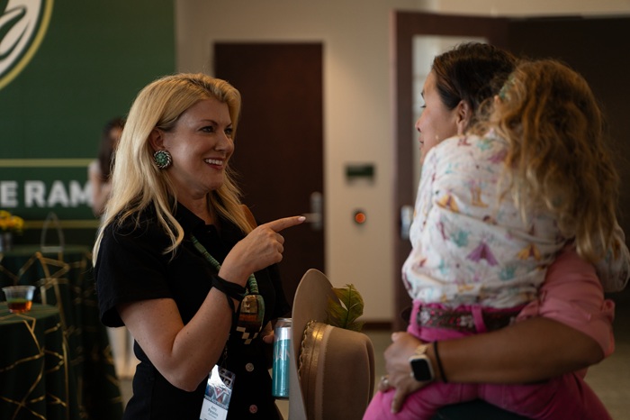 President Amy Parsons chats with an event participant and her young daughter at the 1870 Exclusive